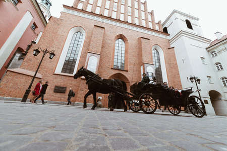 WARSAW, POLAND - Mar, 2018 Tourists ride in a carriage with horses in the historic part of the city of Warsaw 1のeditorial素材