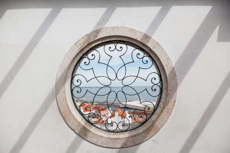Circle window - Santa Luzia viewpoint (miradouro), with view to Alfama old town and Tagus river - Lisbon, Portugal.の写真素材