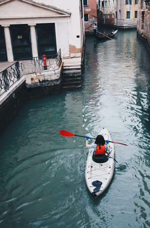 Girl canoeing in Venice with kayak - Alternative way to visit famous City in Italyの写真素材
