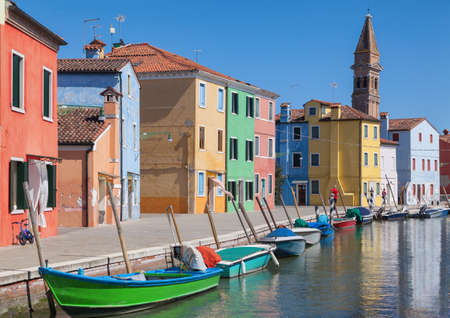 Colorfull facade Houses and bell tower on the island of Burano plus reflection in the water. Waterways with traditional boats - Venice- Italyの写真素材