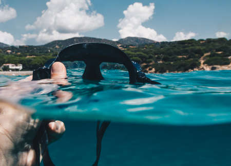 first person view Half underwater view of Man taking off Diving mask for scuba diving.の写真素材