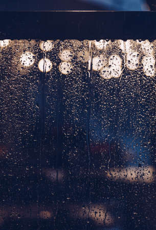 nigh light drop water on glass whit light in the streetの写真素材