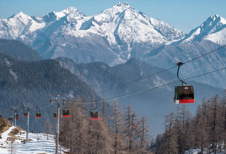 Row of cable cars against snowy italian mountains