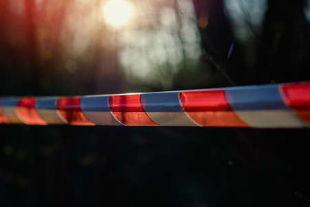 close-up of RED WHITE SIGNAL TAPE - evidence area murder keep out message
