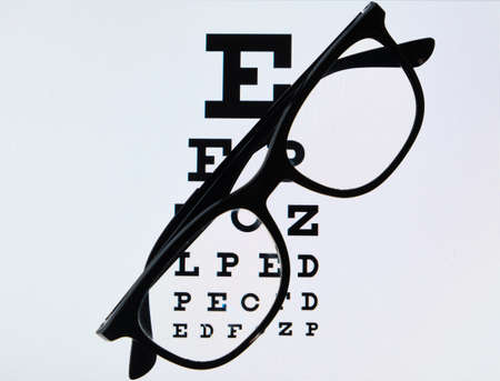 eye chart on tablet and the glass with E Standard Logarithm Eyesight Table on top of the light screenの写真素材