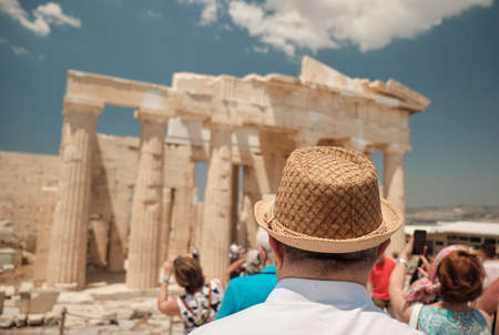 old senior man with hat 60s looking at the the Ancient Famous temple in the Acropolis area in a sunny day in the capital of Greece - Athens - travel destination conceptの写真素材