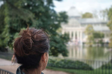 woman looking at Palacio de Cristal, The Crystal Palace - Madrid Spainのeditorial素材