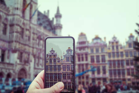 taking photo with smart phone at grand place - typical facade in Brussels with bike on the wall Belgiumの写真素材