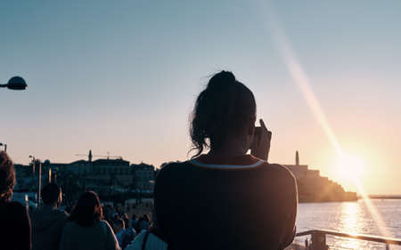 girl taking photo of the Landscape view at sunset of the Old Giaffa (Jaffa) in Tel Aviv, ISRAELの写真素材