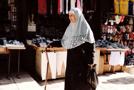 old muslim woman walking in the market along the streets of Jerusalem - Muslim side - ISRAEL - DEC 2019のeditorial素材