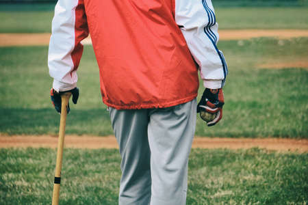 Baseball coach holding ball and watching the game
