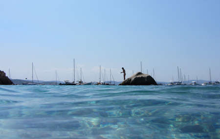girl ready to jump into the crystal clear water - travel destination - summer conceptの写真素材