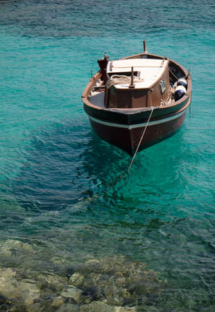 little old wood boat in the turquoise sea in sardinia - travel conceptの写真素材