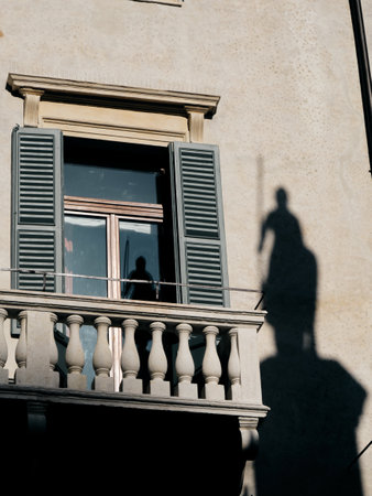 facade of an ancient building with shadow and reflection of a statue of a warrior knight with horseの写真素材