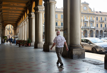 Elderly Man Walking Under the Arcades in Piazza Garibaldi, Alessandriaの写真素材