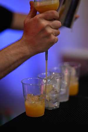 Close-up of a Hand preparing a Cocktail at a Bar, showcasing the Art of Mixology and the Craftsmanship in creating Delicious Drinks.の写真素材