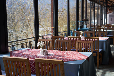 Cozy restaurant interior featuring traditional wooden furniture and neatly arranged dining tablesの写真素材