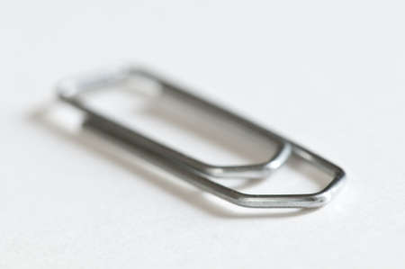 Closeup of a silver paperclip on white backgroundの写真素材