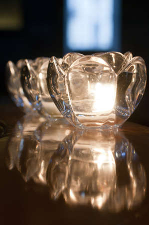 Candle holders on a shiny wooden surfaceの写真素材