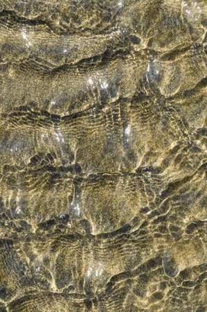 Closeup detail of beach sand shapes and forms induced by water