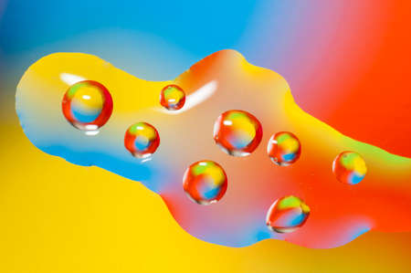 Oil drops on water surface lit from beneath.の写真素材