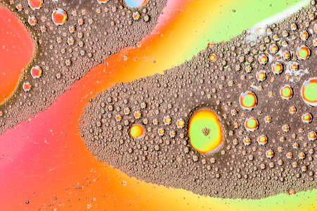 Oil drops on water surface lit from beneath.の写真素材