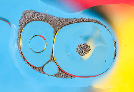 Oil drops on water surface lit from beneath.の写真素材