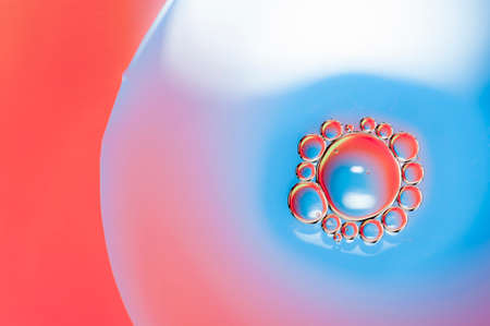 Oil drops on water surface lit from beneath.の写真素材