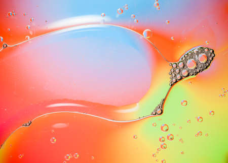 Oil drops on water surface lit from beneath.の写真素材