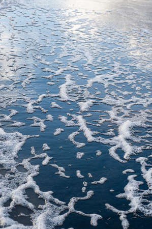 Colorful foam and bubbles induced by pollution in sea water on  beachの写真素材