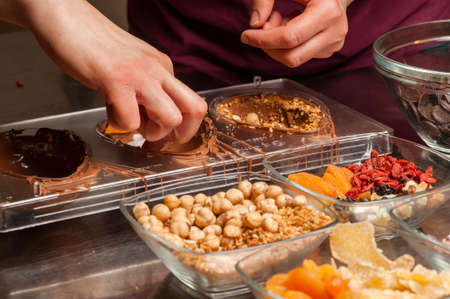 Ingredients and preparation of italian Easter milk and dark choccolate eggs and sweetsの写真素材