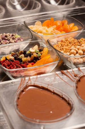 Ingredients and preparation of italian Easter milk and dark choccolate eggs and sweetsの写真素材