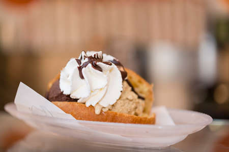 Artisan preparation of classic Italian maritozzo, sweet bun, with ice cream gelato and whipped cream.の写真素材