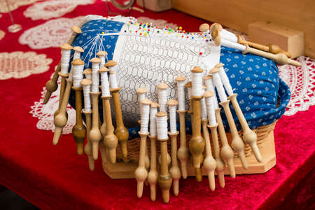 Close up of lace pillow to woven fabric by hand
