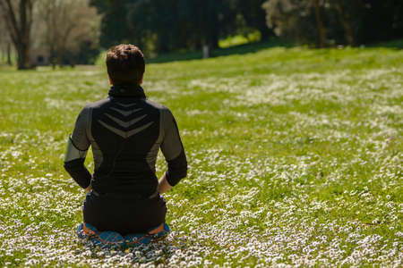 Man sitting on grass for meditation and relaxationの写真素材