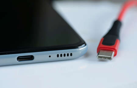 Detail of front entrance of USB-C cable plug and port on smartphone.の写真素材