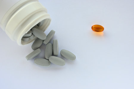 Detail of blue and orange pills in packaging and isolated for healthcareの写真素材