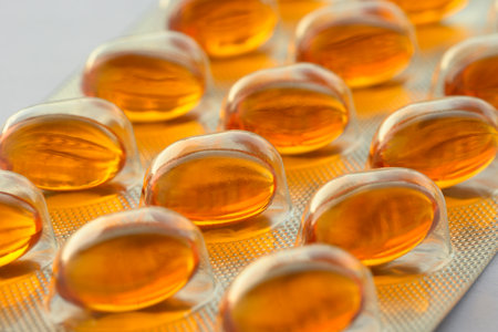 Detail of orange pills in packaging and isolated for healthcareの写真素材