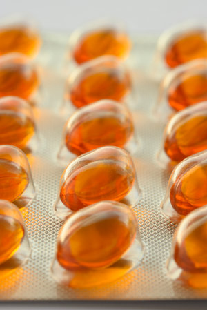 Detail of orange pills in packaging and isolated for healthcareの写真素材