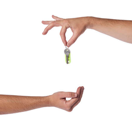Hand just about to drop apartment/house keys to the buyers hand.
