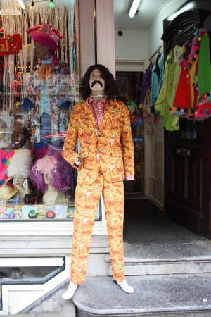 shop window display of clothes and party costumes. mannequin dressed as a famous character with rude...
