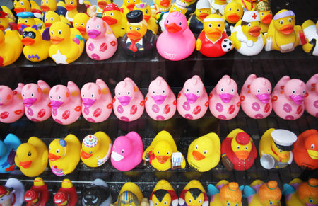 so many yellow rubber ducks for the bathroom. sales items on display, toy animals disguised with many different types of clothes.のeditorial素材