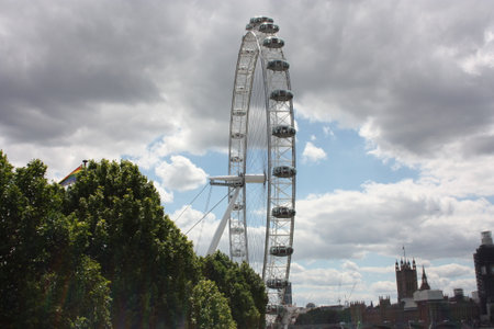 the british london eye of england on the river under a gray and cloudy spring skyのeditorial素材