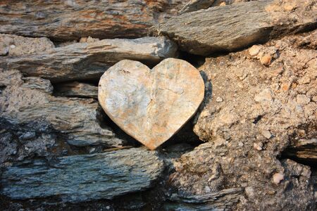 heart shape of rock between stones between dust and soilの写真素材