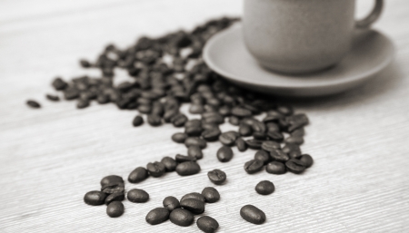 cup of coffee and coffee beans on the wooden tableの写真素材