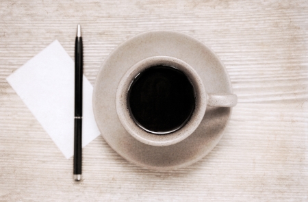 Artwork in painting style, cup of black coffee, pen and blank sheet of paper on wooden tableの写真素材