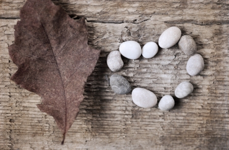 artwork  in retro style,  heart shape of stones, red leaf, wooden backgroundの写真素材