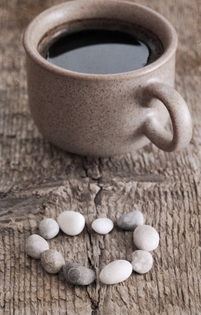 artwork  in retro style,  cup of coffee, heart shape of stones, wooden backgroundの写真素材