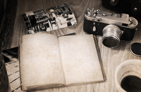 Artwork in retro style, old-fashioned camera, opened book, empty cup of coffeeの写真素材