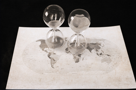 Artwork in retro style, two sandglasses, political map of the world, time passingの写真素材